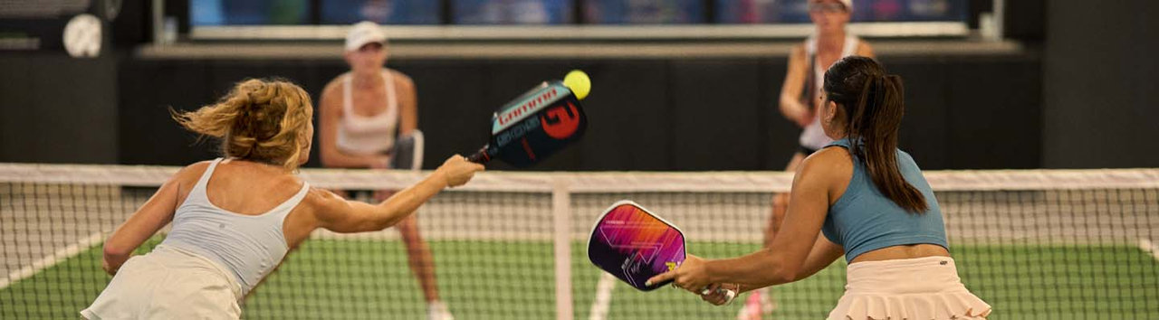 Four women playing pickleball on a court App Partnership page Banner Image