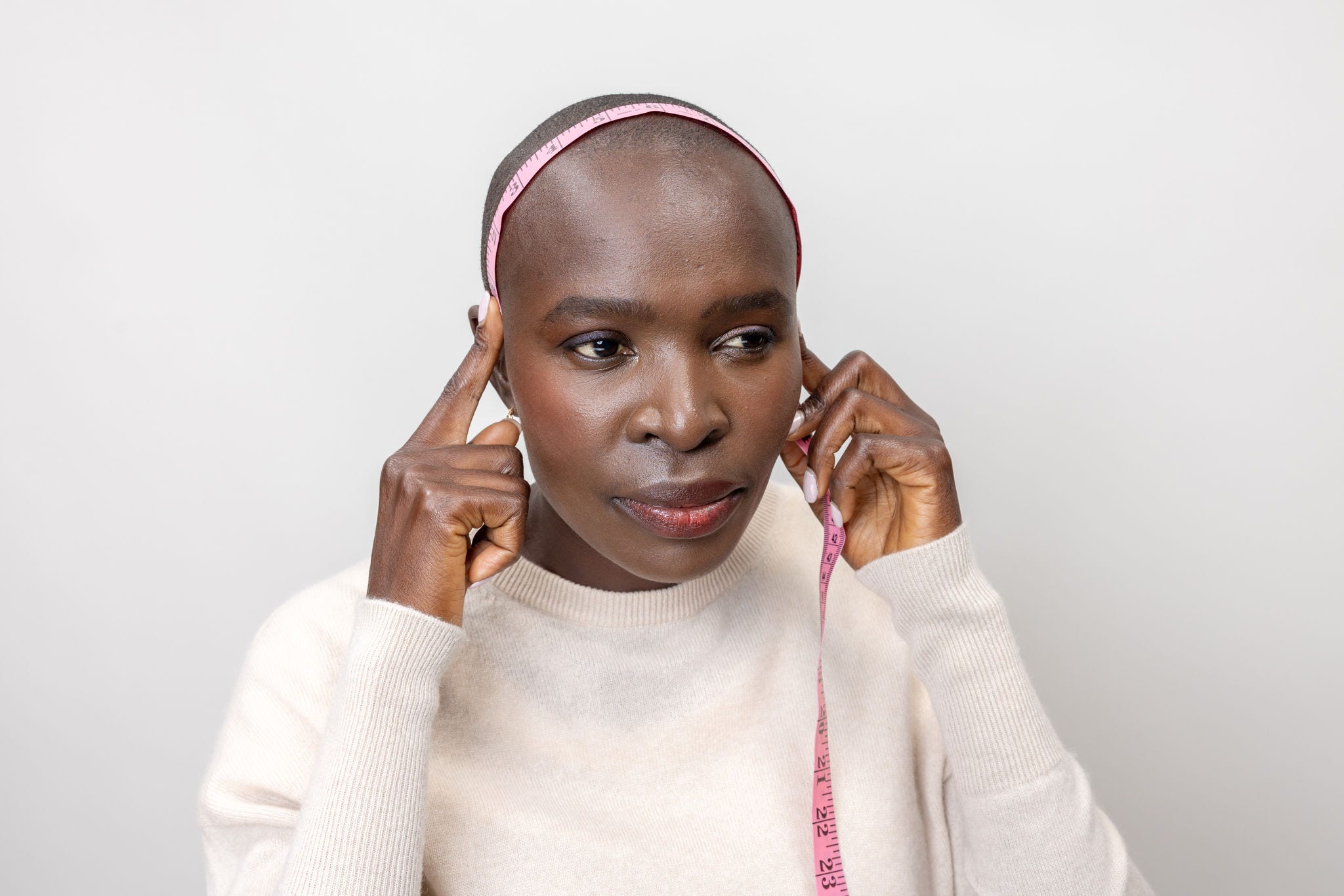 woman measuring side to side of head with soft measuring tape