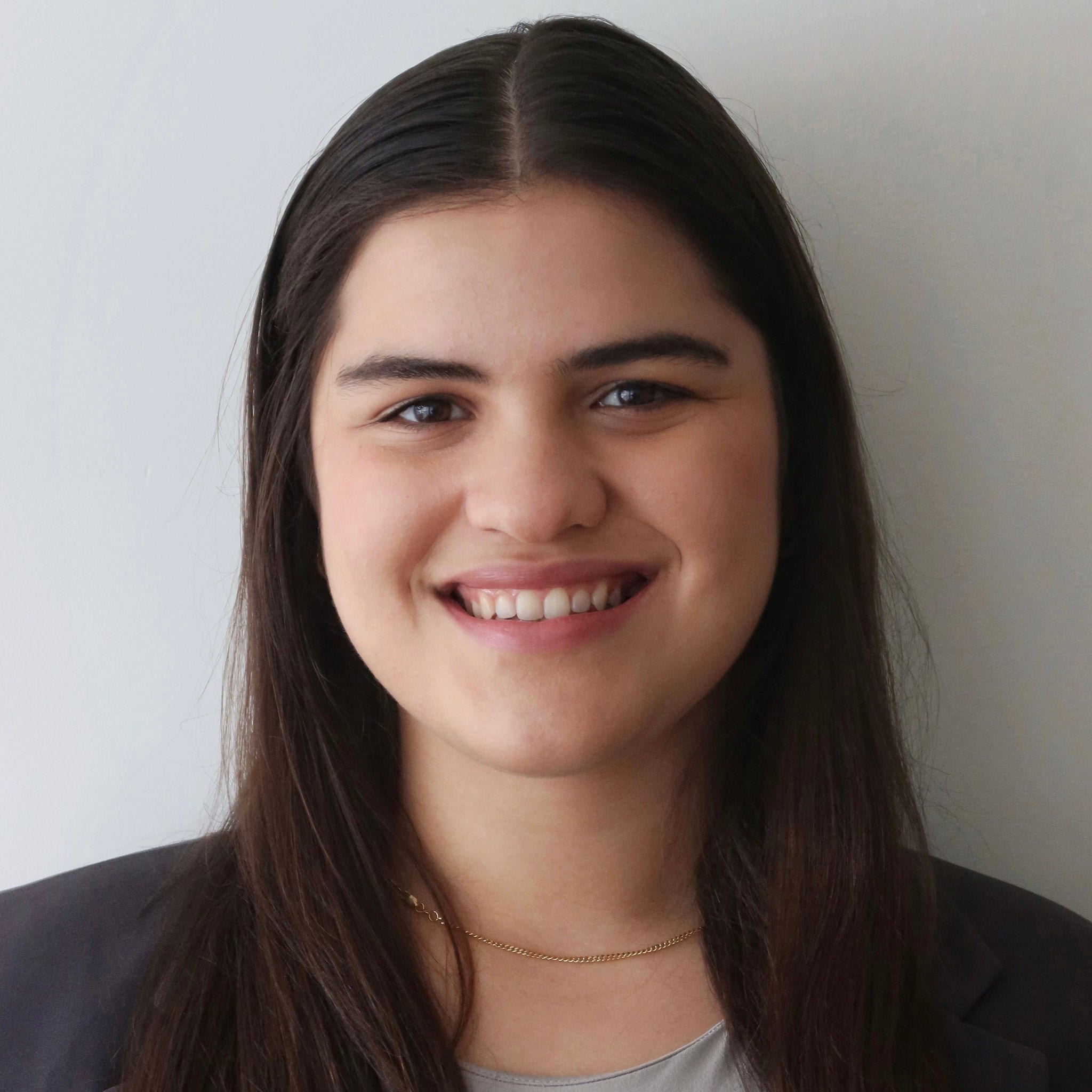 Headshot of Natalia Mazzitelli, MPH, in a light gray shirt and a dark gray blazer