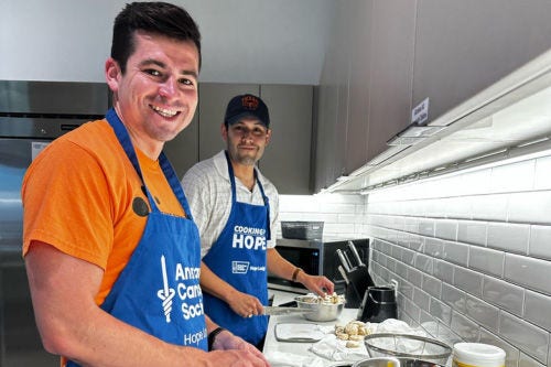 Two men inside a kitchen coooking - ACS GenNow Network Mission Image