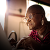 Smiling woman with glasses using a laptop at home