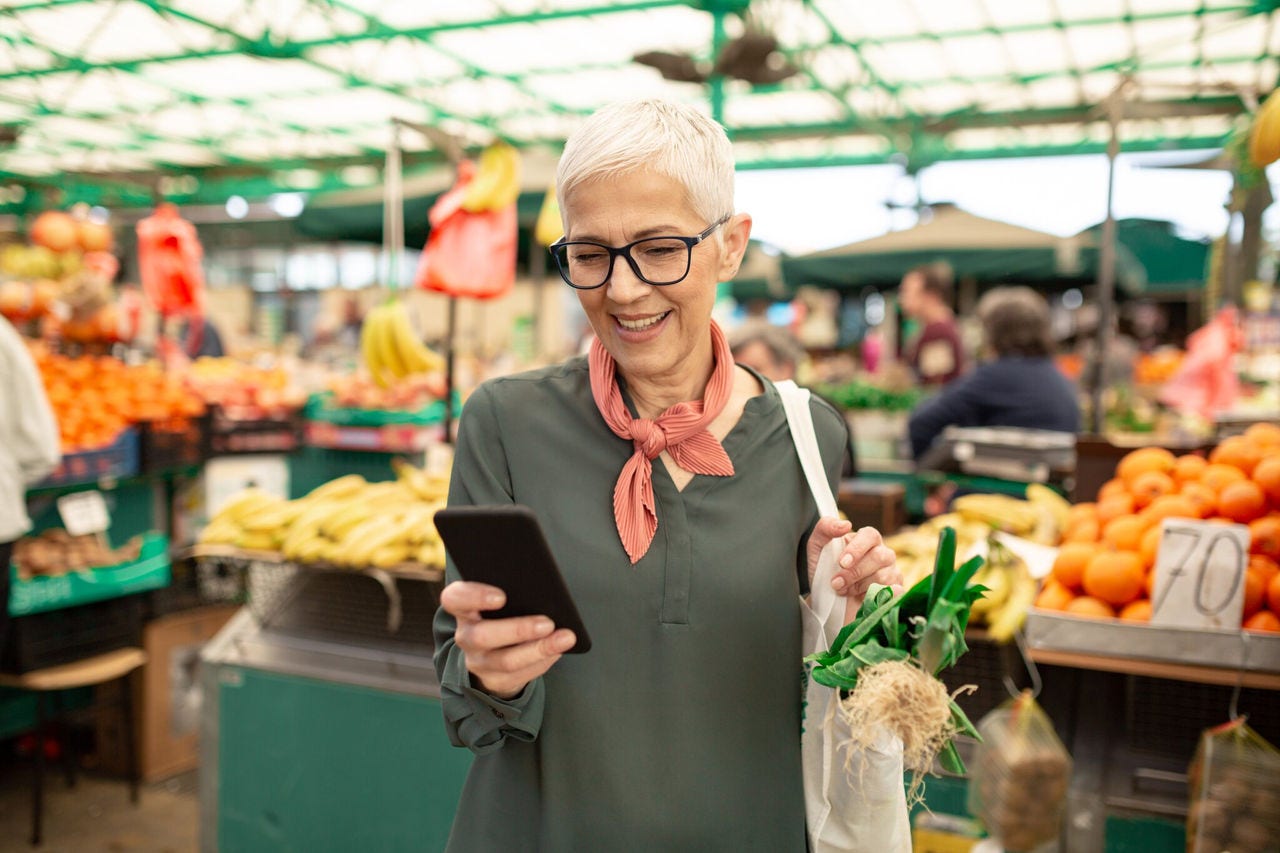 a woman using her smartphone while shopping at a market