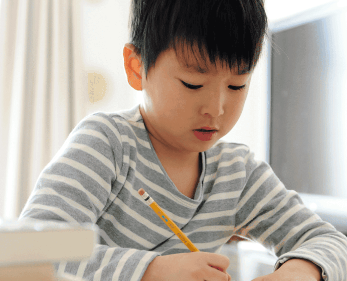 asian boy practicing school work