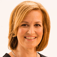 White woman with neck length red hair and silver necklace