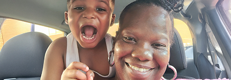 A woman(Aleta) and her grandson smile for a selfie in a vehicle