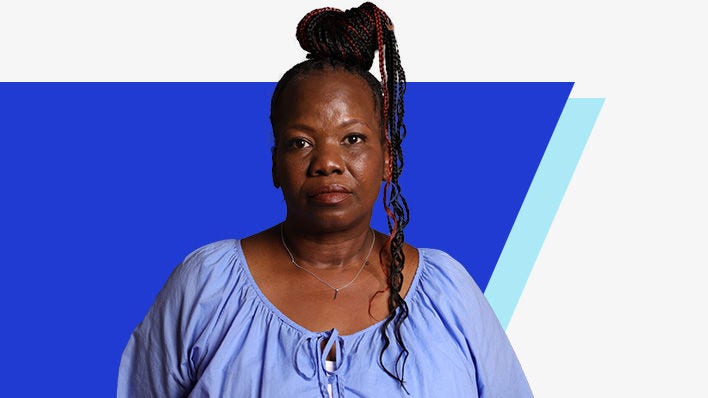 Portrait of a woman with braided hair, wearing a light blue blouse, standing against a blue and light blue geometric background