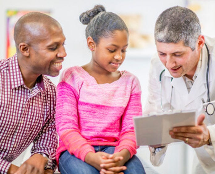 A doctor a young girl and her father focus on a tablet, illustrating a collaborative approach to health education and communication.