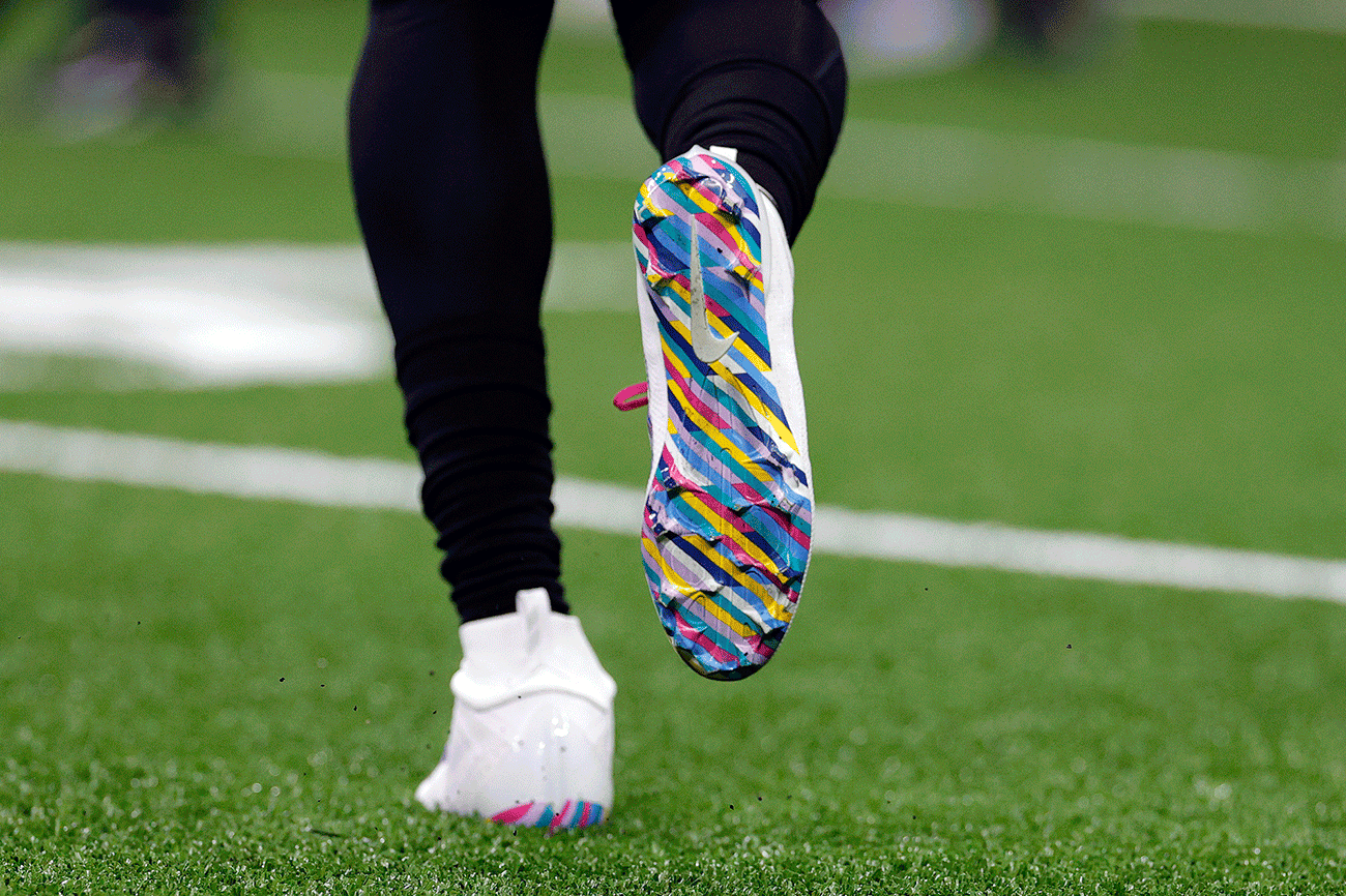  A close-up of a football player's colorful cleats on a field.