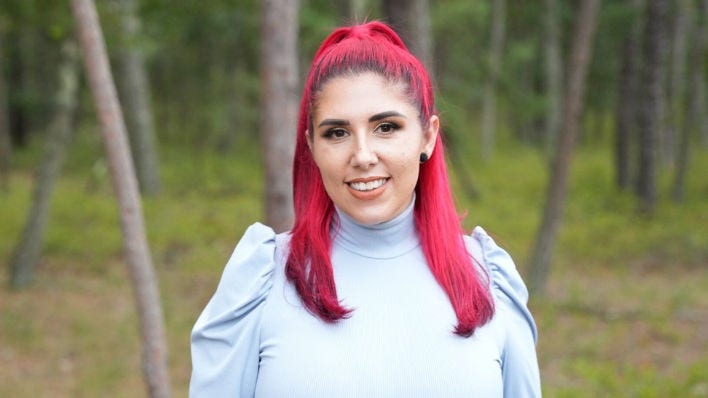 spanish woman with red hair standing in the woods