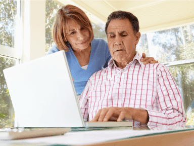 An older couple looking at a laptop together