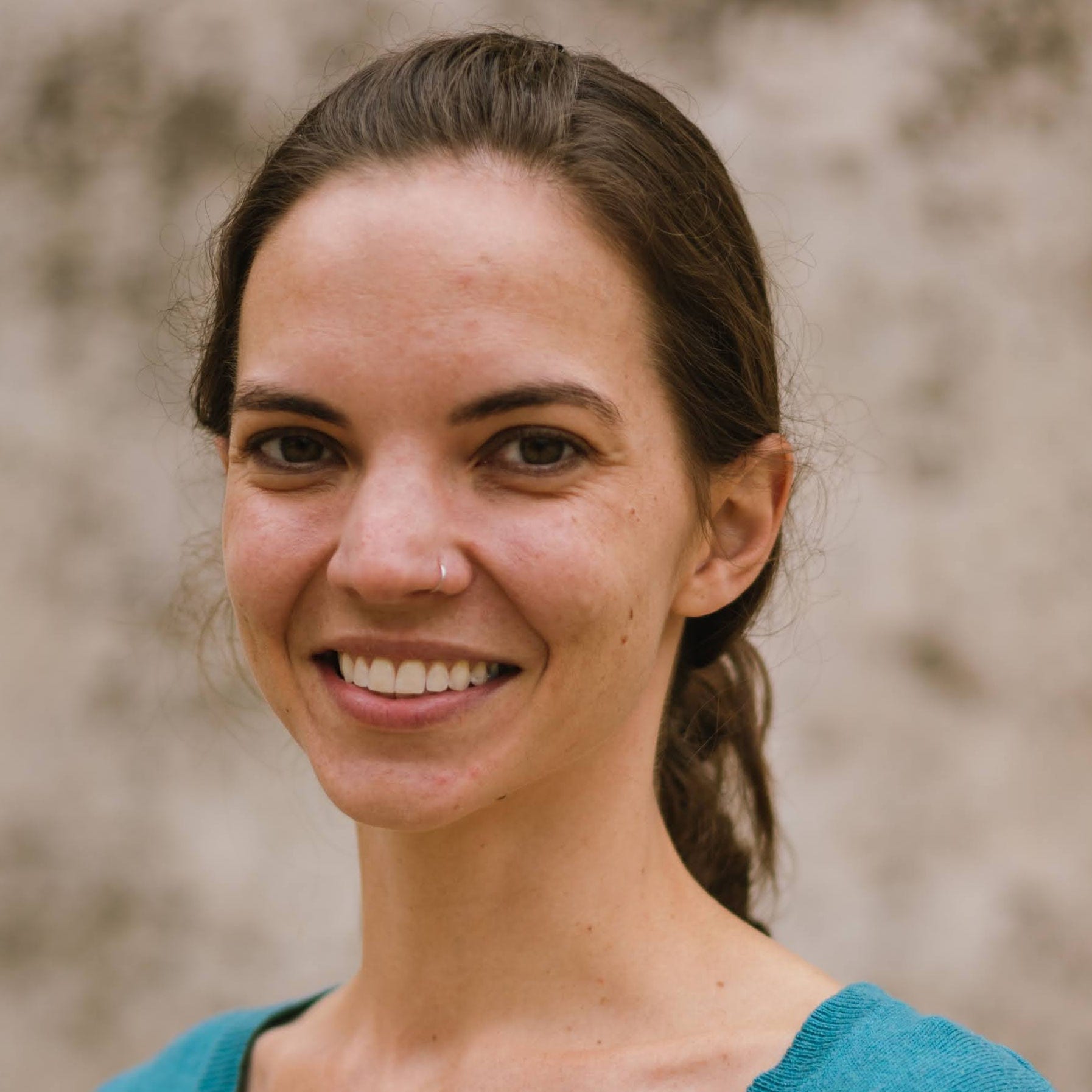 Headshot of postdoctoral fellow Brigitte Pfluger in a teal sweater