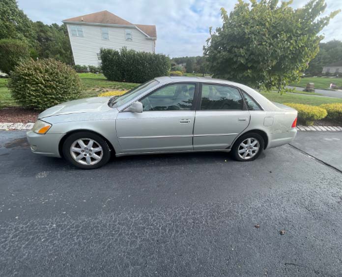 A picture of a Toyota Avalon parked in a driveway. The vehicle was donated to the American Cancer Society Cars for a cure program.