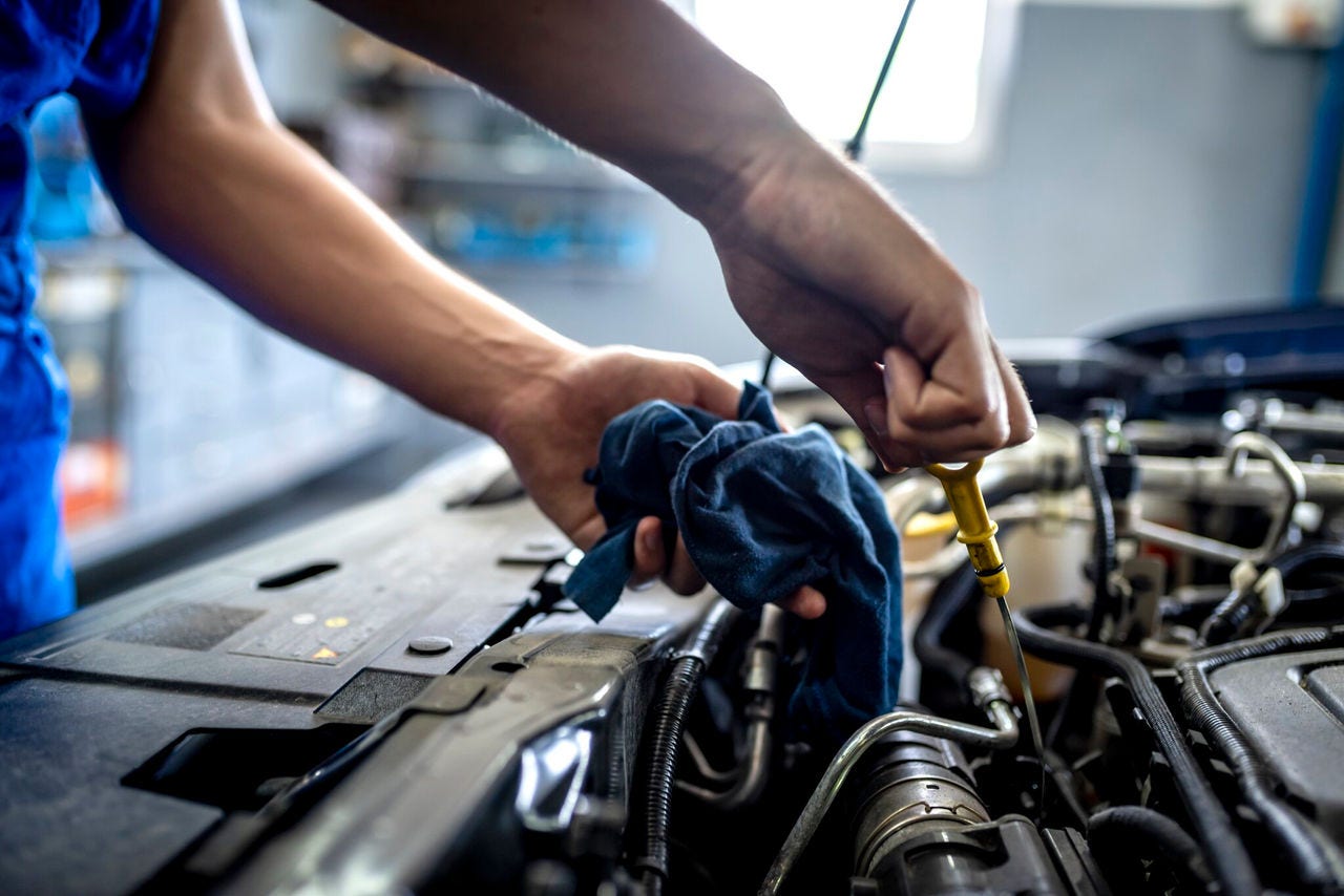 Mechanic performing maintenance on a car engine in a workshop