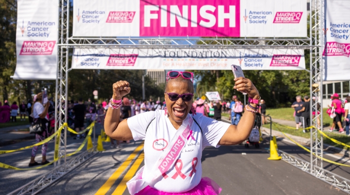 Breast cancer survivor crosses the finish line at a Making Strides Against Breast Cancer event in Orlando, FL