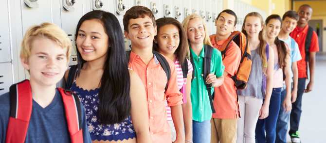 group of smiling high school kids lined up in front of lockers
